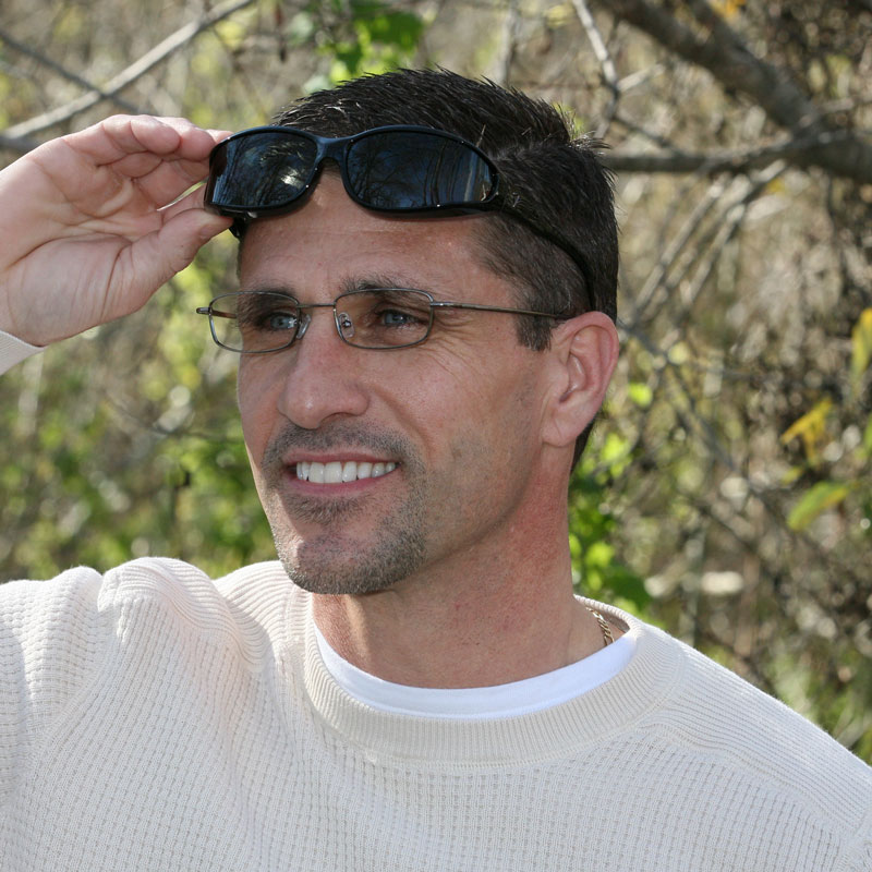 Man shields his eyes from solar radiation with a pair of Vistana fitovers in black.