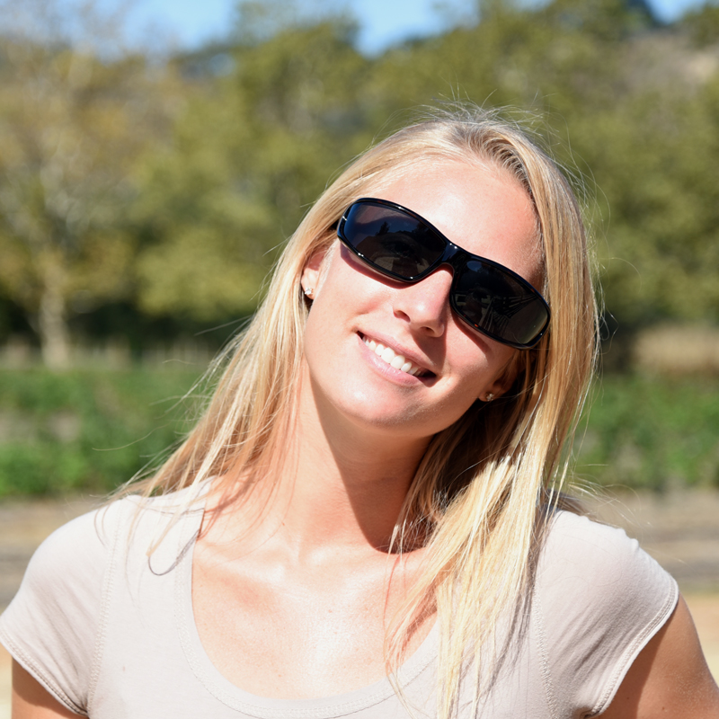 Woman wears black polarized vistana fit over sun glasses to shield her eyes from solar radiation.