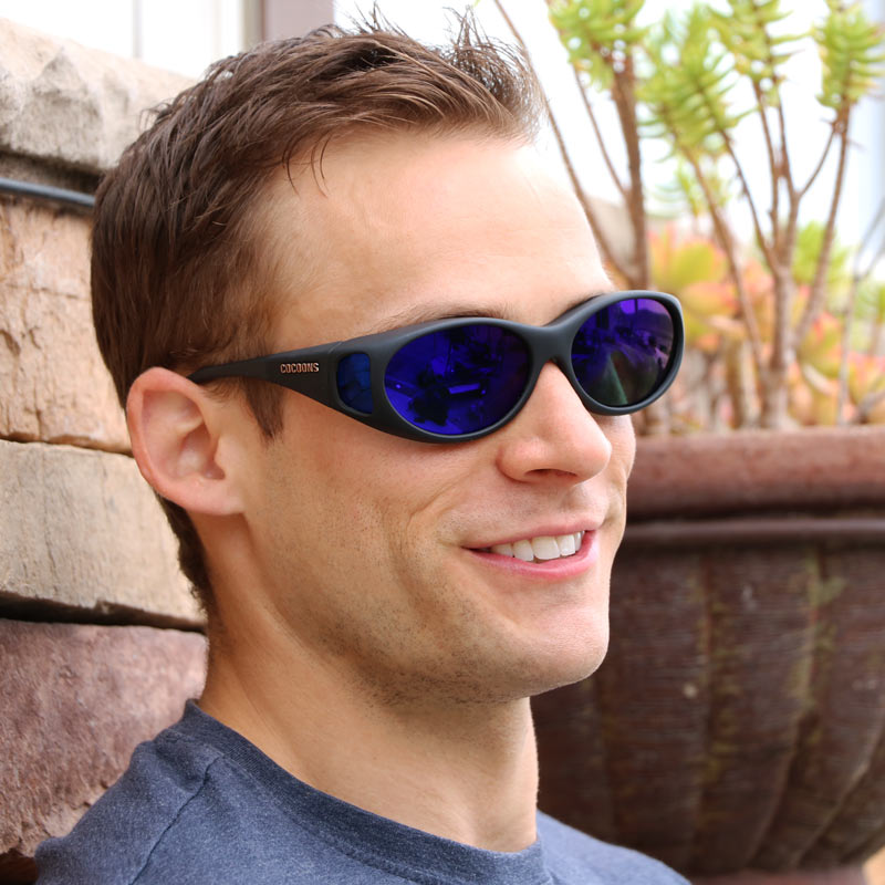 cocoons fitover sunglasses feature OveRx tech that makes for the best fitover sunglasses in the USA. Mark wears a pair with blue mirror lens finishes and a gray base.